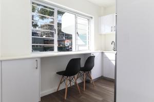 a kitchen with two black stools at a counter at Modern & stylish apartment in Cape Town