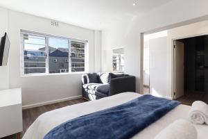 a bedroom with a bed and a couch and a window at Modern & stylish apartment in Cape Town