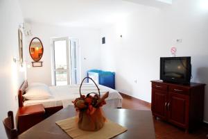 a living room with a table and a tv and a bed at Apartments Baron in Sveti Stefan