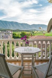 a white table and chairs on a balcony with mountains at Twin Villa Tragjas in Vlorë