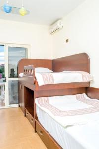 two bunk beds in a room with a window at Twin Villa Tragjas in Vlorë