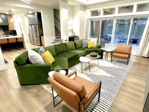 a living room with a green couch and chairs at Sport Court! Hot Tub! Putting Green! Bunk Room! in Lava Hot Springs