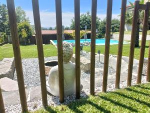 a statue in front of a fence with a pool at Kasa da Caniçada - Gerês in Braga