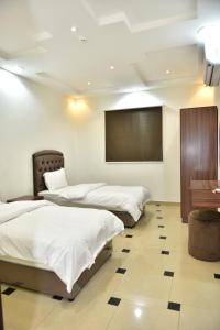 a room with three beds and a projection screen at شقق المكان الراقي للشقق المخدمة in Riyadh +49 photos