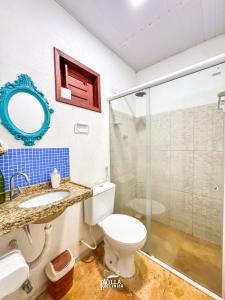 a bathroom with a toilet and a glass shower at Pousada Villa Pontinha in Icaraí