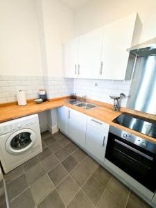 a kitchen with a sink and a washing machine at Stylish Westbrook Apartment in Kent +4 photos