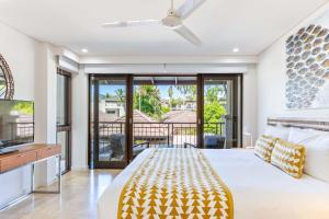 a bedroom with a bed and a balcony at Seascape Holidays at Seascape Temple in Port Douglas +122 photos