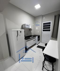 eine Küche mit Kühlschrank und Herd in der Unterkunft Confortavél Apartamento com AC, perto do Aeroporto in Guarulhos