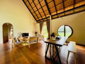 a living room with a table and a dining room at Peace in Ranong in Ban Cho