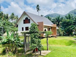 a house with a fence in front of it at Peace in Ranong in Ban Cho