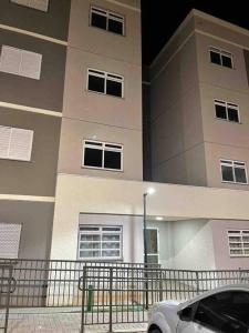 Un coche blanco aparcado delante de un edificio en Aconchego Familiar, en Londrina
