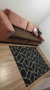 un sofá y una alfombra en la sala de estar en Aconchego Familiar, en Londrina