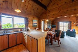 kuchnia i jadalnia w chacie z bali w obiekcie Misty Mountain Hideaway w mieście Hanmer Springs