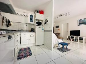 a kitchen with white cabinets and a blue stool at Port-Vendres - T2 climatisé, parking, WIFI - 3* - FR-1-309-388 in Port-Vendres