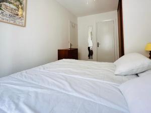 a large white bed in a bedroom with a lamp at Port-Vendres - T2 climatisé, parking, WIFI - 3* - FR-1-309-388 in Port-Vendres +3 photos