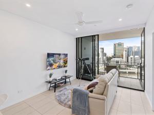Una sala de estar con un sofá y una ventana grande. en 2BR Apartment in South Brisbane with Spectacular River View, en Brisbane