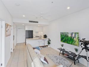 sala de estar blanca con sofá y cocina en 2BR Apartment in South Brisbane with Spectacular River View, en Brisbane