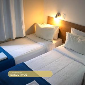 two beds in a hotel room with at Bela Vista Hotel in Arujá