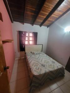 ein Schlafzimmer mit einem Bett in einem Zimmer mit einem Fenster in der Unterkunft Townhouse 3 habitaciones in Ciudad Guayana