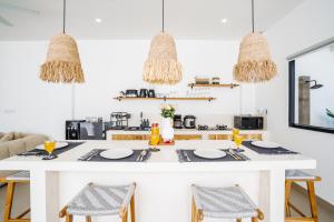 een keuken met een wit eiland met een tafel en stoelen bij Villa Valentina - 2 bedroom private luxury villa in Canggu quiet area in Canggu