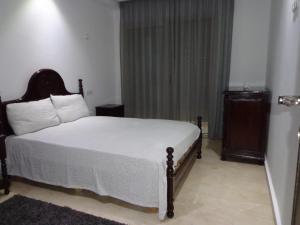 カサブランカにあるLuxor Guest Houseの白いシーツと窓のあるベッドのある寝室