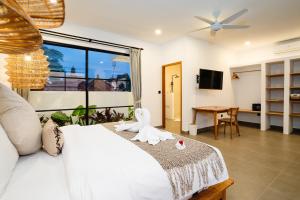 een slaapkamer met een wit bed en een groot raam bij Villa Valentina - 2 bedroom private luxury villa in Canggu quiet area in Canggu