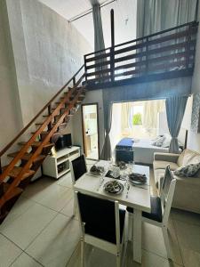 a living room with a dining table and a staircase at Boutique FLAT 1 min da Praia in Luis Correia