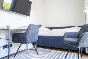 a bedroom with a bed and two chairs and a desk at Johouse Zingst Johouse Zimmer 13 in Zingst