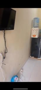 a corner of a room with a tv on a wall at Din's House in Legian