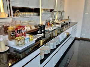 a buffet line in a restaurant with plates and food at Khonkaen Residence in Khon Kaen