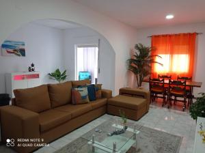 una sala de estar con un sofá y una mesa en Lovely Apartment In Mindelo City Center, en Mindelo