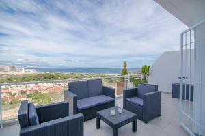 a balcony with chairs and a table and the ocean at Novabeach by Mar Holidays in Puerto Marino