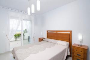 a white bedroom with a bed and a window at Novabeach by Mar Holidays in Puerto Marino +24 photos