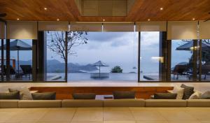 a living room with a couch and a large window at Selong Selo Resort and Residences in Selong Belanak