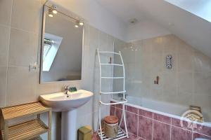 a bathroom with a sink and a mirror and a tub at Les 2 pointes in Plouézec