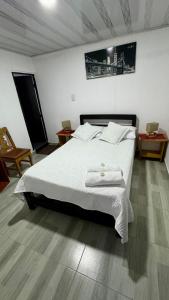 a bedroom with a bed with two towels on it at Hermosa casa de campo en Barbosa in Barbosa