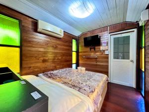a small bedroom with a bed and a tv at MrT Riverside Sampran มิสเตอร์ที โฮมสเตย์&ช้องนาง in Sam Phran