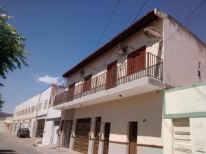 - un bâtiment blanc avec un balcon dans une rue dans l'établissement Pousada Santa Helena, à Juazeiro do Norte