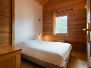 a bedroom with a bed in a wooden cabin at Chalet confortable 6 pers, 3 ch, à côté des pistes La Balme/Fernuy - FR-1-304-291 in La Clusaz