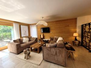 a living room with a couch and a table at Appartement spacieux et lumineux, 3 chambres, proche centre Les Gets, terrasse, parking, calme. - FR-1-598-167 in Les Gets
