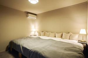a large white bed in a room with two lamps at The ONE -fujiyoshida- in Fujiyoshida