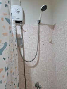 a shower in a bathroom with a shower head at Arabella's Home in Dumaguete +16 photos