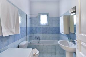 Un baño con bañera, inodoro y lavabo. en Aegean Villa in Paros, en Santa Marina