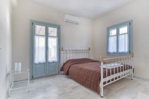 Un dormitorio con una cama y dos ventanas. en Aegean Villa in Paros, en Santa Marina 9 fotos más