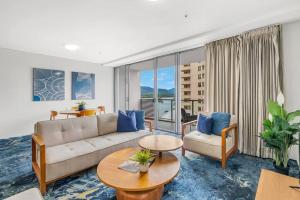a living room with a couch and a table at Panoramic Views at Harbour Light on the Waterfront in Cairns