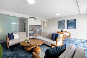 a living room with a couch and a table at Panoramic Views at Harbour Light on the Waterfront in Cairns