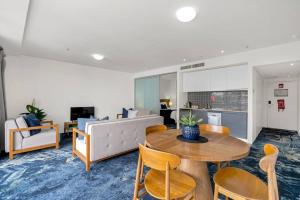 a living room with a table and chairs and a couch at Panoramic Views at Harbour Light on the Waterfront in Cairns
