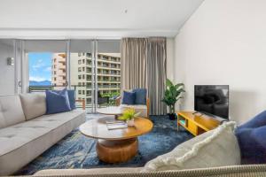a living room with a couch and a table at Panoramic Views at Harbour Light on the Waterfront in Cairns