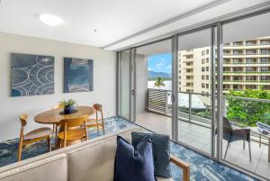 a living room with a couch and a table at Panoramic Views at Harbour Light on the Waterfront in Cairns