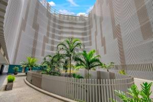 a large building with palm trees in front of it at Panoramic Views at Harbour Light on the Waterfront in Cairns